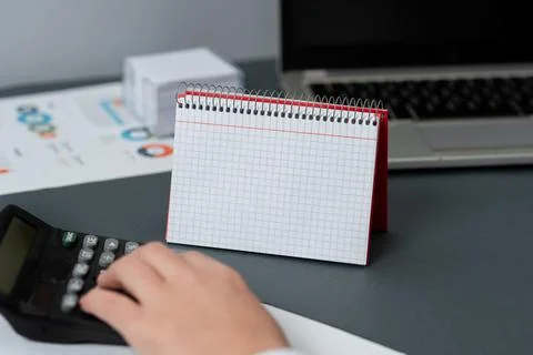 Blank Opened Spiral Notebook With A Calculator And A Pen Placed Over A Table Foto stock