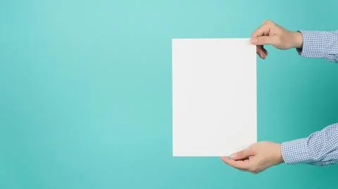 Blank or empty board A4 paper in man's hands on green mint or Tiffany Blue ba Stock Photos