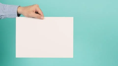 Blank or empty board A4 paper in man's hands on green mint or Tiffany Blue ba Stock Photos