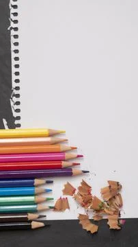 Blank page of a notebook as a mock up next to pencils of different colors on  Stock Photos
