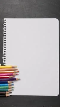 Blank page of a notebook as a mock up next to pencils of different colors on  Stock Photos