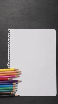 Blank page of a notebook as a mock up next to pencils of different colors on  Stock Photos