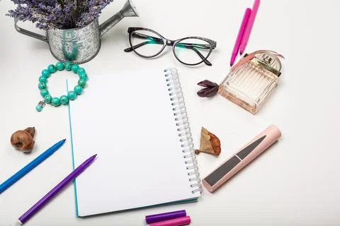 Blank page of spiral notepad on white table. Crayon pencil and pen flat lay Stock Photos
