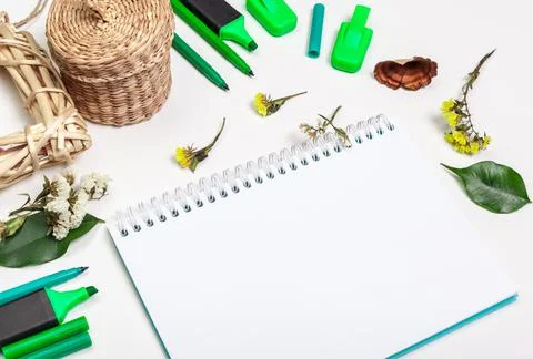 Blank page of spiral notepad on white table. Crayon pencil and pen flat lay Stock Photos