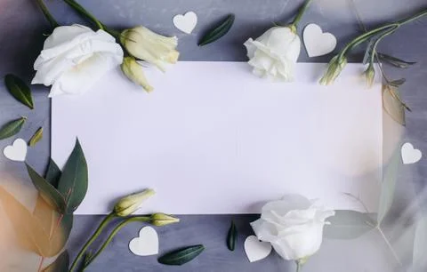 Blank paper copy space. Frame with flowers. Silk ribbon. Gray background. Sim Stock Photos