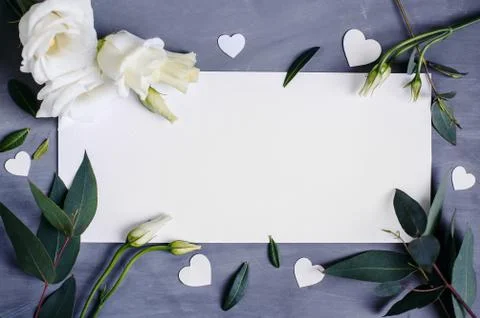 Blank paper copy space. Frame with flowers. Silk ribbon. Gray background. Sim Stock Photos