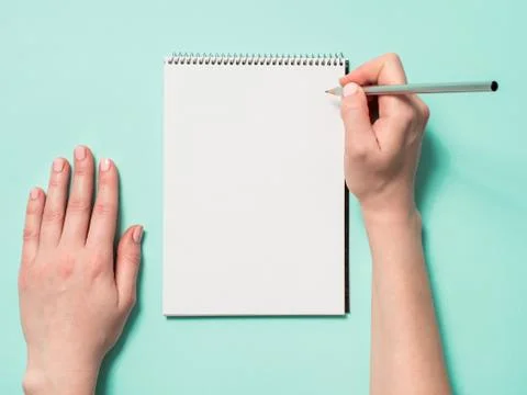 Blank paper notebook and female hands with pencil Stock Photos
