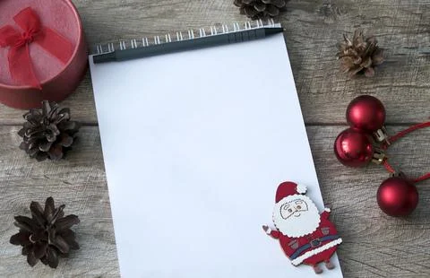 Blank paper, notebook for notes with pen on wooden background. Pine cones, gi Foto stock
