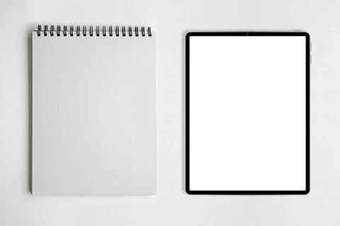 Blank paper notepad and tablet on white table background. Stock Photos