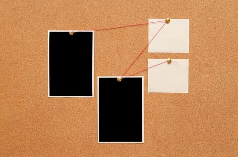 Blank paper notes and an empty photo are pinned to a cork board. The concep.. Stock Photos