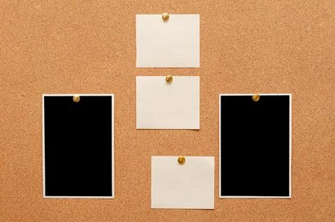 Blank paper notes and an empty photo are pinned to a cork board. The concept  Stock Photos