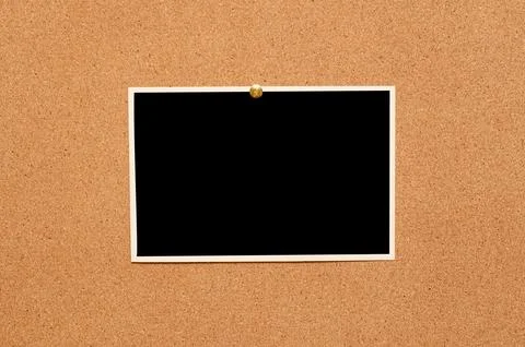 Blank paper notes and an empty photo are pinned to a cork board. The concep.. Stock Photos