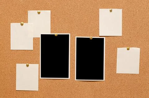 Blank paper notes and an empty photo are pinned to a cork board. The concept of Stock Photos