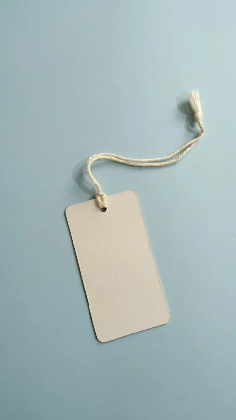 Blank paper price tag with string moving and casting a shadow on a serene li Stock Footage 341499534
