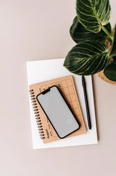 Blank path screen mobile phone with mockup on various notepads on beige bac.. Stock Photos