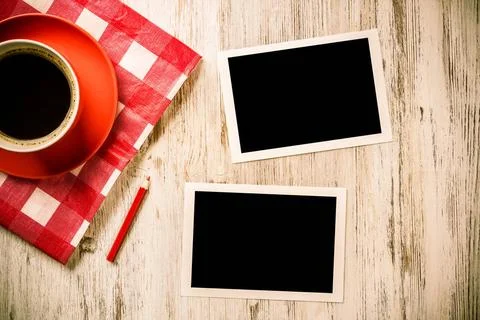 Blank photo frames on table Coffee cup on napkin photos and pen on wooden ... Stock Photos