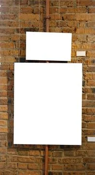 Blank picture frames on brick wall with glowing lamp, mock up Stock Photos