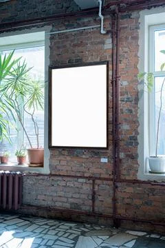 Blank picture frames on brick wall with glowing lamp, mock up Stock Photos