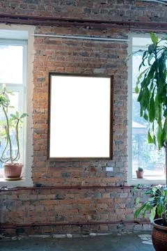 Blank picture frames on brick wall with glowing lamp, mock up Stock Photos