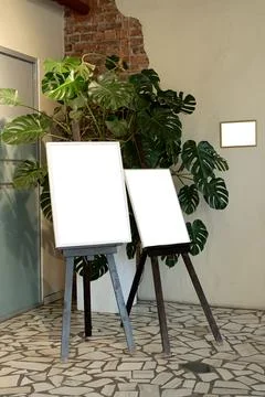 Blank picture frames on brick wall with glowing lamp, mock up Stock Photos