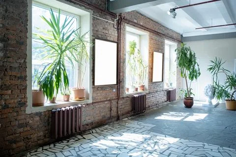 Blank picture frames on brick wall with glowing lamp, mock up Stock Photos