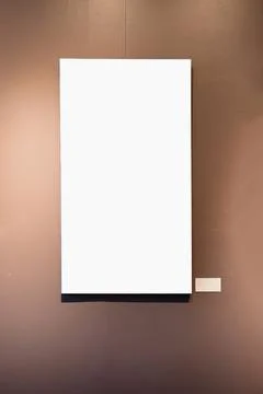 Blank picture frames on brown wall with glowing lamp, mock up Stock Photos