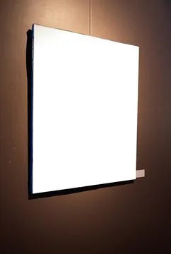 Blank picture frames on brown wall with glowing lamp, mock up Stock Photos