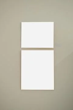 Blank picture frames on grey wall with glowing lamp, mock up Stock Photos
