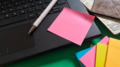 Blank pink sticky note placed on a black laptop keyboard surface Stock Photos