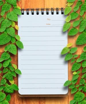 Blank planning notebook on wood background with ivy fixing tree. conservation Stock Photos