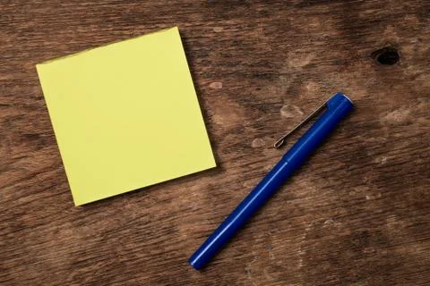 Blank post it note and pen on wooden table Stock Photos