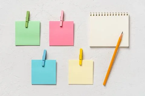 Blank post-it notes, spring notepad and pensil on a white concrete background. Stock Photos
