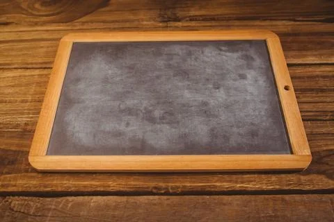 Blank rectangular chalkboard with wooden frame is lying flat on rustic wood Foto stock