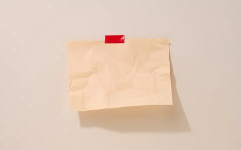 Blank rectangular crumpled beige sheet of paper glued on a light beige backgr 스톡 사진