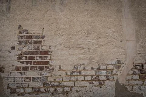 A blank red brick wall with stucco that is heavily weathered Fotos de archivo