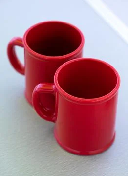 Blank red ceramic mugs on light background Stock Photos