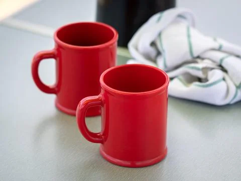 Blank red ceramic mugs on light background Foto stock