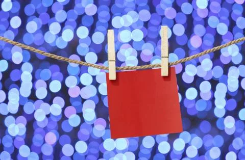 Blank red paper notes hanging on clothesline for design in Christmas Day on b Foto stock