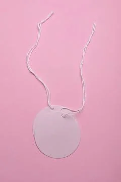 Blank round tag with white string on pink background Stock Photos