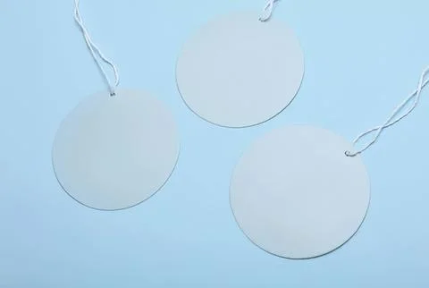 Blank round tags with strings on a blue background Stock Photos