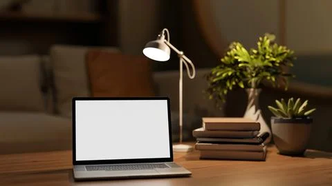 Blank screen computer with books and desk lamp on wooden drawer table and d.. イラスト素材