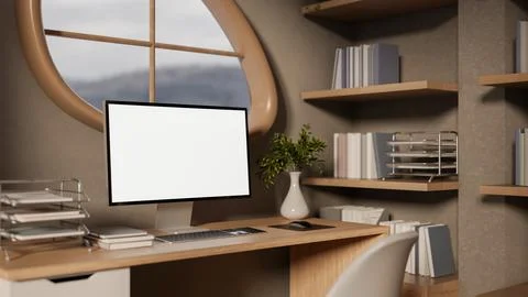 Blank screen computer on wooden study table aside bookshelf under oval wind.. イラスト素材