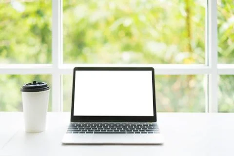 Blank screen laptop computer and coffee cup on table at coffee cafe with natu Stock Photos