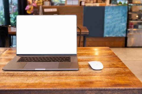 Blank screen laptop with mouse on table in cafe. Stock Photos