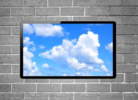 Blank screen LCD tv with blue sky hanging on a wall Stock Photos