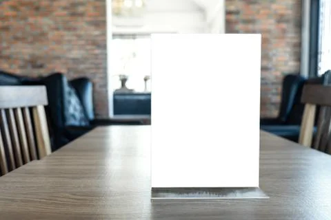 Blank screen mock up menu frame standing on wood table in coffee cafe and res Stock Photos
