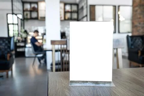 Blank screen mock up menu frame standing on wood table in coffee cafe and res Stock Photos