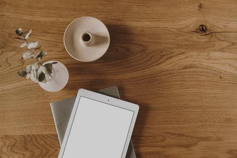 Blank screen tablet, decorations, eucalyptus branch on wooden table. Flat lay Stock Photos