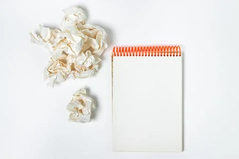 A blank sheet of notebook with crumpled paper around. Crumpled paper on a white  Stock Photos