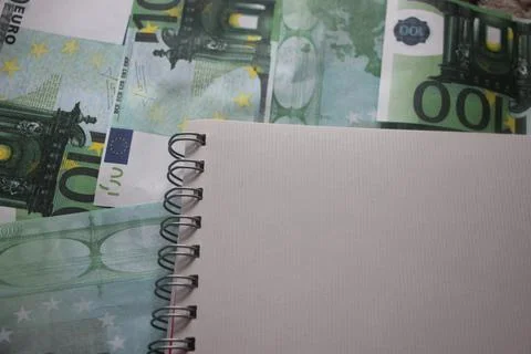 Blank sheet of notebook put on 100 euros bills. Business accounting concept Stockfoto's